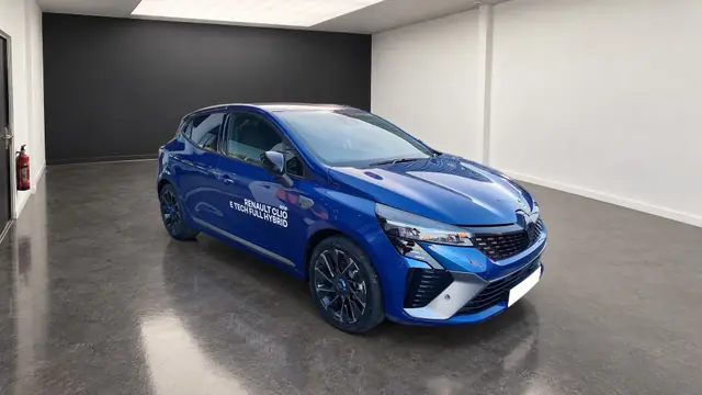 Une Clio bleue dans le box photo d'une concession, faite avec Studio Auto